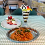 ナポリタンスパゲッティ、チョコレートパフェ、苺のナポレオンパイ。テーブルクロスや皿も昭和の雰囲気