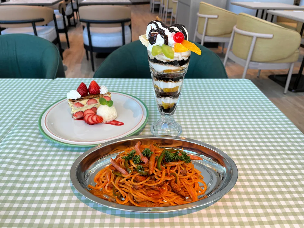 ナポリタンスパゲッティ、チョコレートパフェ、苺のナポレオンパイ。テーブルクロスや皿も昭和の雰囲気