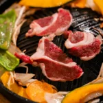 炭火の上にジンギスカン鍋を置き、じっくり焼き上げる