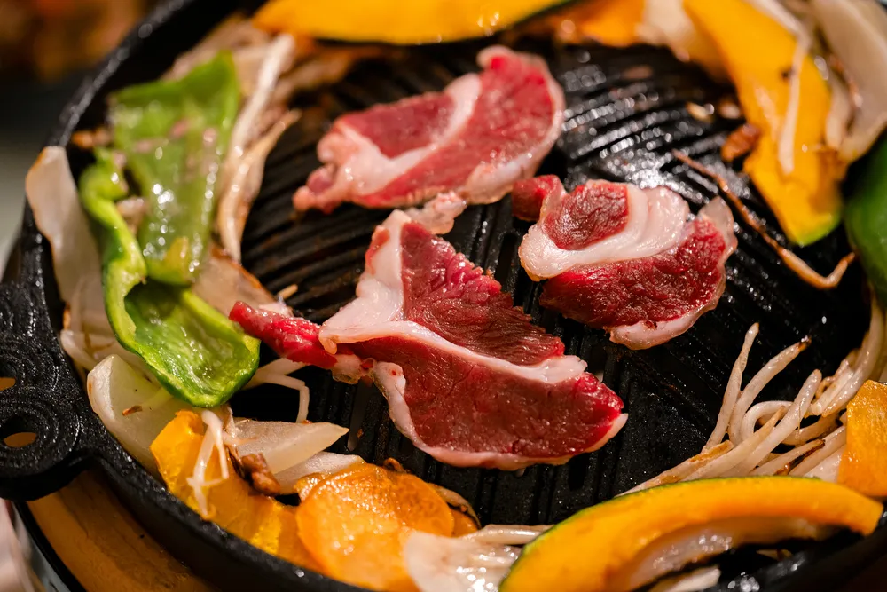 炭火の上にジンギスカン鍋を置き、じっくり焼き上げる