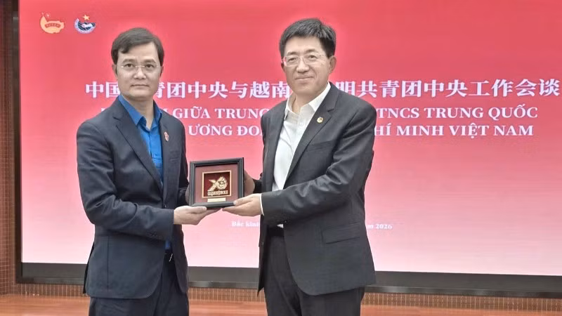 Comrade Bui Quang Huy presents Comrade A Dong with a commemorative plaque of the 13th National Congress of the Ho Chi Minh Communist Youth Union.