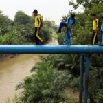 Sejumlah siswa berjalan melintasi pipa air di Kelurahan Kampung Baru, Medan, Sumatera Utara, Sabtu (18/4/2026). Sebagian siswa di daerah itu terpaksa berangkat dan pulang sekolah dengan melintasi pipa air karena jembatan yang biasa mereka lalui ambruk dan tak kunjung dibangun kembali. ANTARA FOTO/Yudi Manar/YU