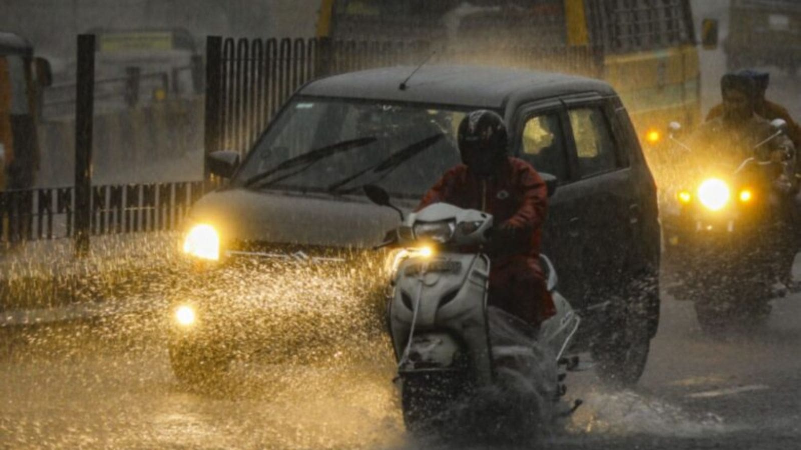 Rainy weather in Hyderabad with vehicles and pedestrians dealing with evening rains.