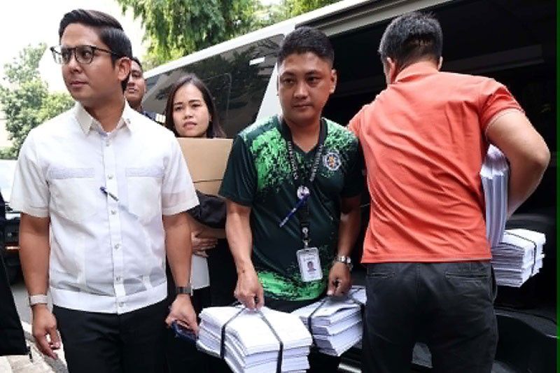 Bitbit ni Assistant Ombudsman Mico Clavano (kaliwa) ang sangkaterbang dokumento nang dumating sa Sandiganbayan, Quezon City nitong Huwebes para pormal na isampa ang kasong plunder at graft laban kay Sen. Jinggoy Estrada kaugnay ng flood control project sa Bulacan.