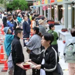 出店ブースでラーメンを受け取る来場者たち=18日（西野正史撮影）