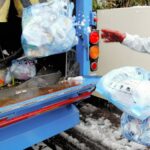 指定ごみ袋で出されたごみを回収する作業員=2005年、八王子市