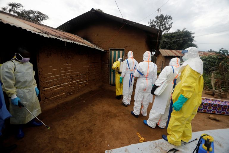 Healthcare workers prepare to enter a house where a woman is suspected of dying of Ebola in eastern Democratic Republic of Congo.