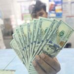 A money changer employee shows US dollar bills at their shop in Quezon City.