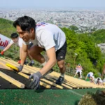 急斜面をはいつくばって登り、ゴールを目指す出場者たち（野沢俊介撮影）