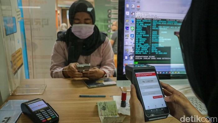 Warga melakukan pembayaran pajak kendaraan bermotor menggunakan fitur QRIS Tap di Mal Pelayanan Publik, Kuningan, Jakarta Selatan, Jumat (24/4/2026). Layanan ini memudahkan wajib pajak menyelesaikan transaksi secara cepat tanpa uang tunai, cukup dengan satu kali tap melalui perangkat pembayaran digital.