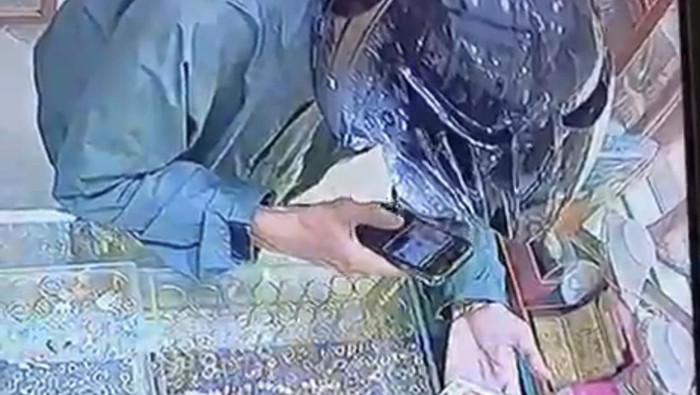 Pelaku sedang memfoto emas milik toko di Medan sebelum membawanya kabur. (Dok. Langkapan Layar CCTV)