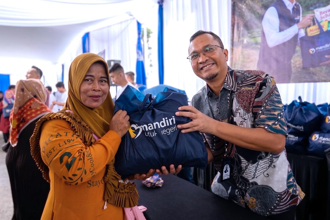 Vice President Bank Mandiri Region VI/Jawa Barat Firman Wahyudi (kanan) menyerahkan paket sembako kepada salah seorang warga di Bandung, Jawa Barat, Selasa (20/5/2026). Penyaluran bantuan digelar dalam rangka memperingati Hari Kebangkitan Nasional sebagai bentuk kepedulian bank pelat merah ini kepada masyarakat di wilayah Jawa Barat. Foto : Dokumentasi Bank Mandiri