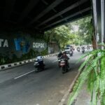Pengendara melintas di kolong fly over Universitas Indonesia yang kini dihiasi ornamen budaya khas Kota Depok.
