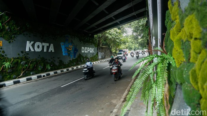 Pengendara melintas di kolong fly over Universitas Indonesia yang kini dihiasi ornamen budaya khas Kota Depok.