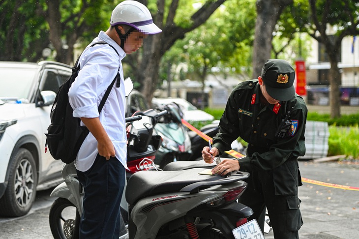 Cảnh sát lập biên bản xử lý một trường hợp chưa đủ điều kiện lái xe - Ảnh: HỒNG QUANG