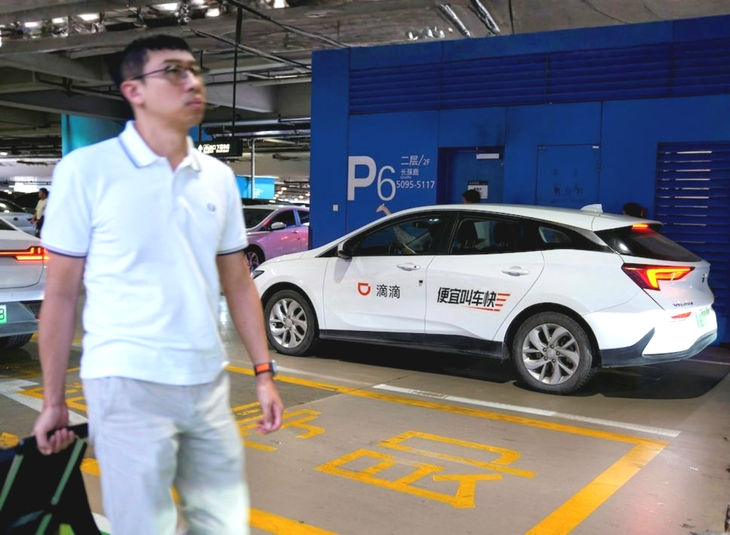 Hành khách sử dụng xe công nghệ Didi tại sân bay quốc tế Hồng Kiều, Thượng Hải - Ảnh: REUTERS