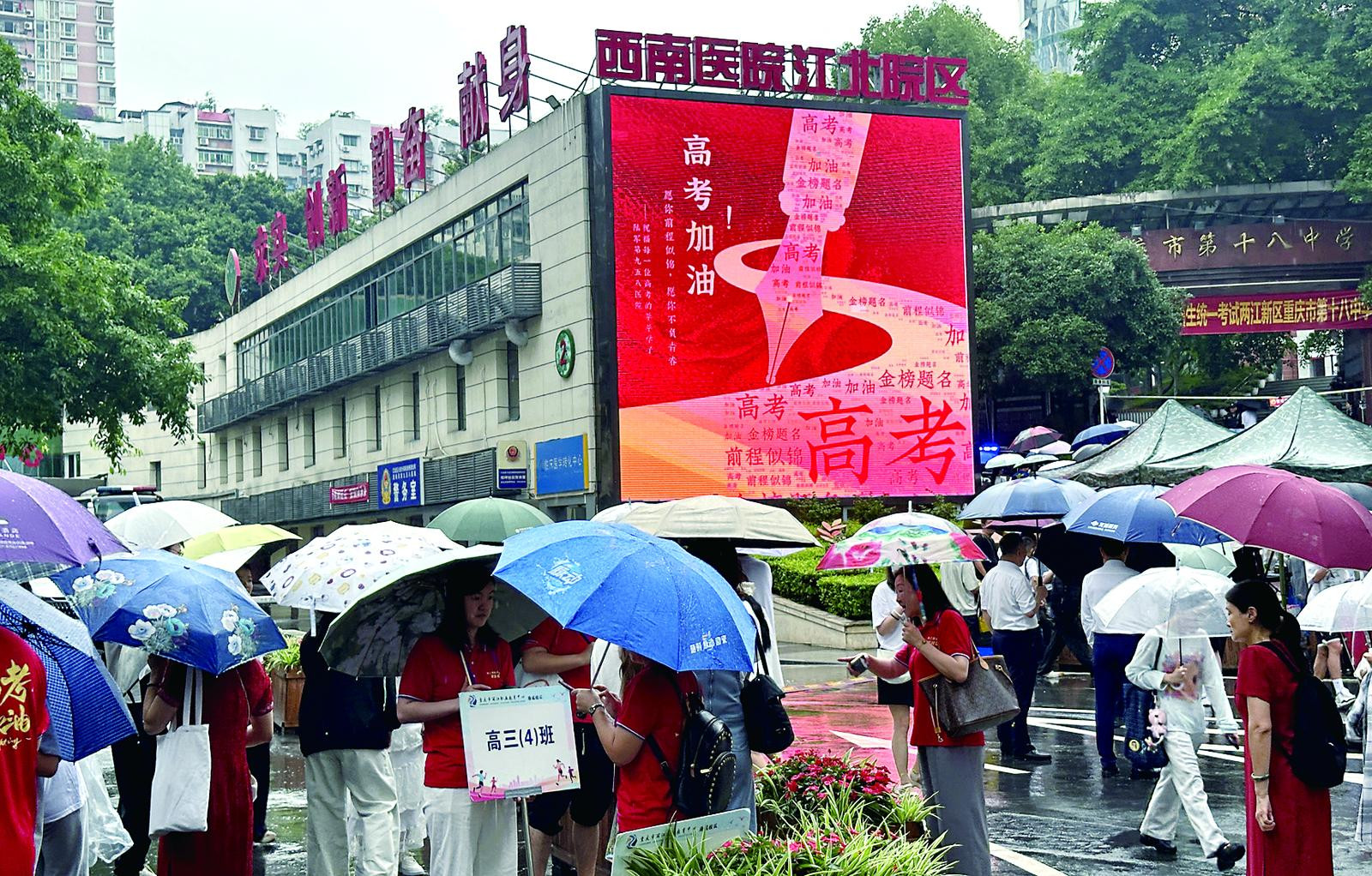 两江新区重庆十八中考点门外，巨幅的公益广告为高考考生加油。上游财经-重庆晨报记者 杨新宇 摄