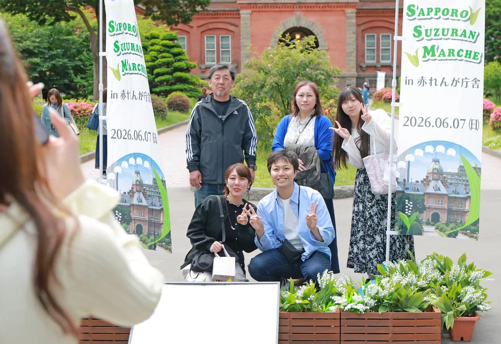 スズランマルシェの会場で記念撮影する来場者（岩崎勝撮影）
