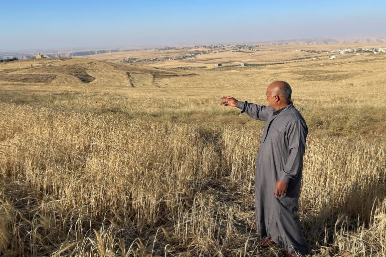A Jordanian citizen inspects damage to his land after rocket debris fell on his property