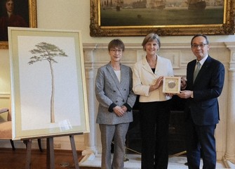 Officials from the United Kingdom and Japan pose for a commemorative photo at the British Embassy in Japan with seeds from the cloned successor of the "Miracle Pine," which are set to be stored in Britain. (Photo courtesy of Sumitomo Forestry Co.)