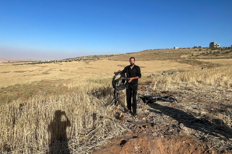 A Jordanian citizen inspects rocket debris that fell on his land