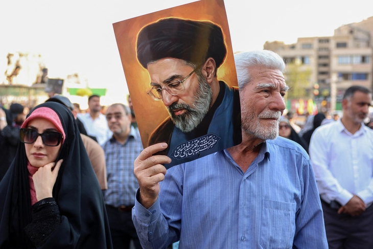 Người dân Iran xuống đường mang theo ảnh chân dung Lãnh tụ tối cao Iran Mojtaba Khamenei - Ảnh: AFP