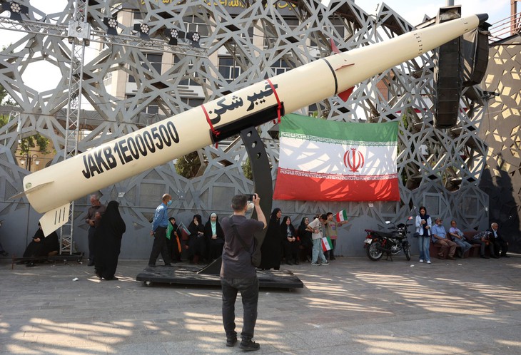 Iranians stand next to a model of the Kheibar missile during a rally showing support for Iran's Supreme Leader Mojtaba Khamenei in Tehran on June 4.