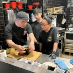 スペインの店に出張し、ラーメン作りを教える西山製麺の社員（左端）＝4月（同社提供）
