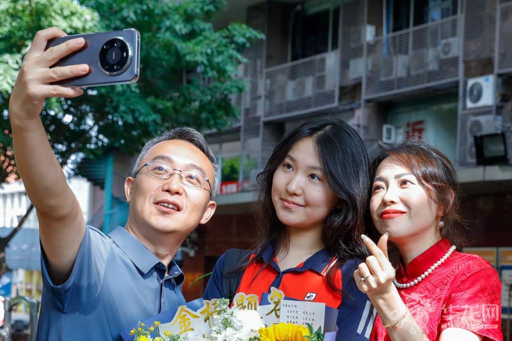 At Chongqing No.1 High School exam venue, after the exam, a candidate who has finished the college entrance exam takes a group photo with family in front of the school. Go for it, young one! May you have a bright future ahead!
