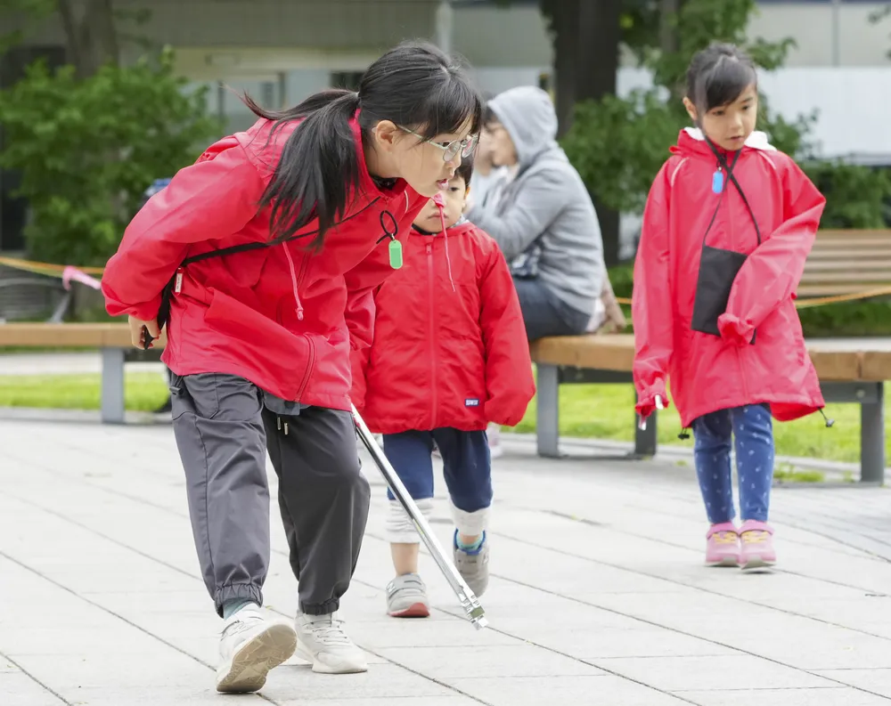 People dancing Yosakoi pick up trash at Odori Park in Sapporo.