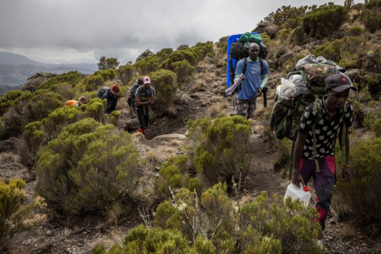 MOUNT KENYA NATIONAL PARK, KENYA - SEPTEMBER 27: Tourists and porters walk up Mount Kenya during a multi-day hike on September 27, 2023 in Mount Kenya National Park, Kenya. The second-highest peak in Africa, Mount Kenya, holds some 11 shrinking glaciers said to be rapidly melting due to the burning of fossil fuels, fires, deforestation and land use changes as well as industrial and agricultural developments. Mount Kenya National park and the forest reserve, combined, are inscribed as a UNESCO World Heritage Site. (Photo by Ed Ram/Getty Images)