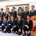 優勝旗とともに写真に納まる山形チームの選手ら＝山形市役所
