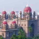A grand historic fort with red domes and lush greenery in the foreground, showcasing traditional Indian a.